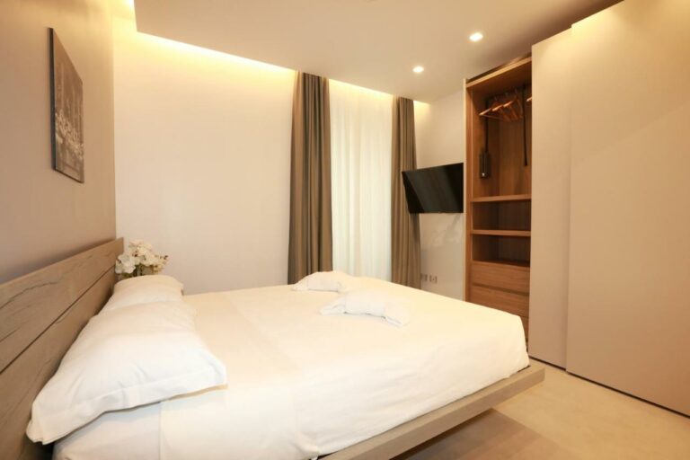 Camera matrimoniale con TV a parete e armadio – Roma Stay Home